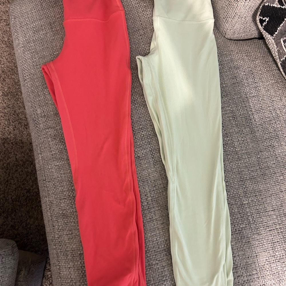 Two pairs of Lululemon Athletica (pink and light green) align Leggings